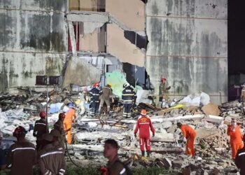 Socorristas procuram por vítimas entre os escombros.