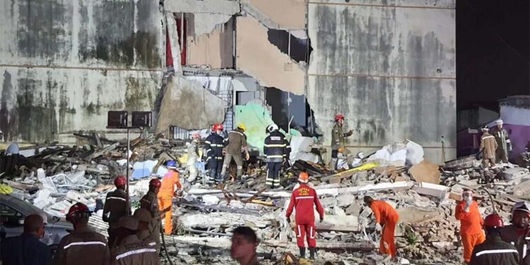 Socorristas procuram por vítimas entre os escombros.