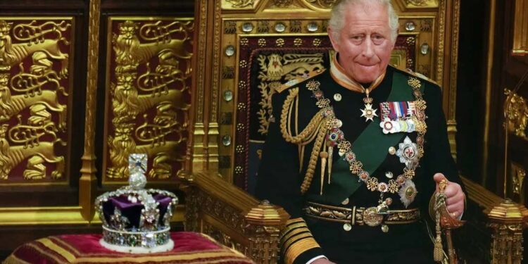 Charles III sentado ao lado da coroa da então rainha durante a abertura do Parlamento, no Palácio de Westminster, em 2022