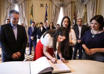 André "é todo sorriso" ao ver sua filha assinando o termo de posse