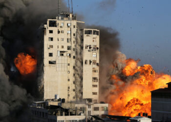 Fumaça e chamas sobem de uma torre destruída por ataques aéreos israelenses.
