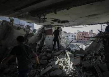 Pessoas procuram corpos e sobreviventes entre os escombros da casa da família.