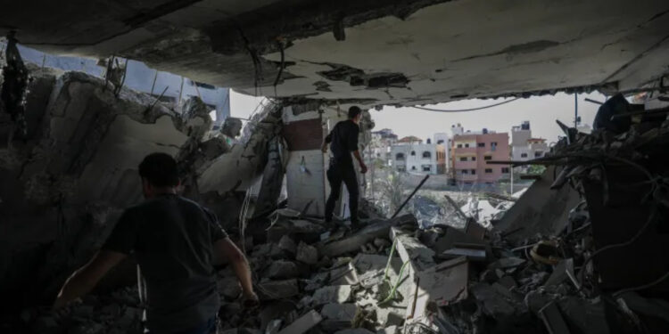 Pessoas procuram corpos e sobreviventes entre os escombros da casa da família.