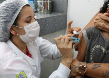 Profissional de saúde vacina criança no Recife. Foto: Hugo Aquino/Divulgação