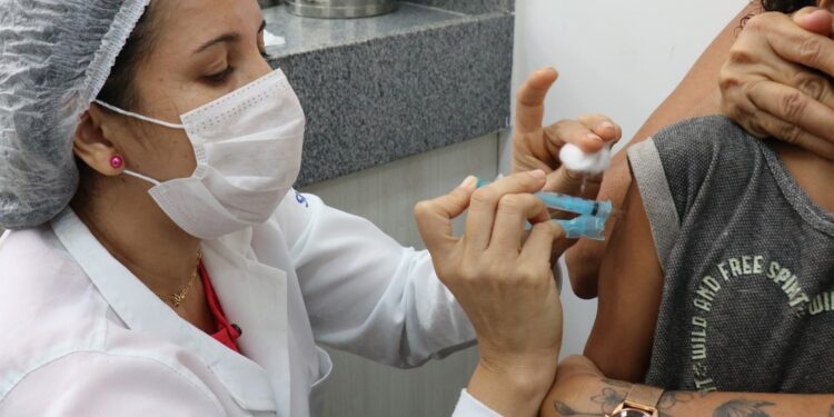 Profissional de saúde vacina criança no Recife. Foto: Hugo Aquino/Divulgação