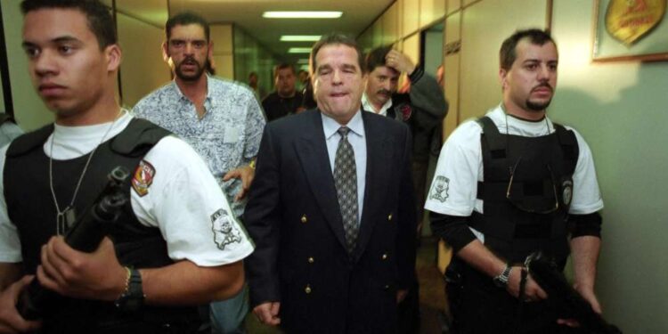 O poderoso banqueiro paulista do jogo do bicho escoltado por policiais civis do GOE, em junho de 1996.