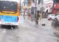 Ônibus passar por avenida alagada no Recife