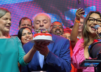 Lula apaga as velas do bolo do PT enquanto Janja canta "parabéns".