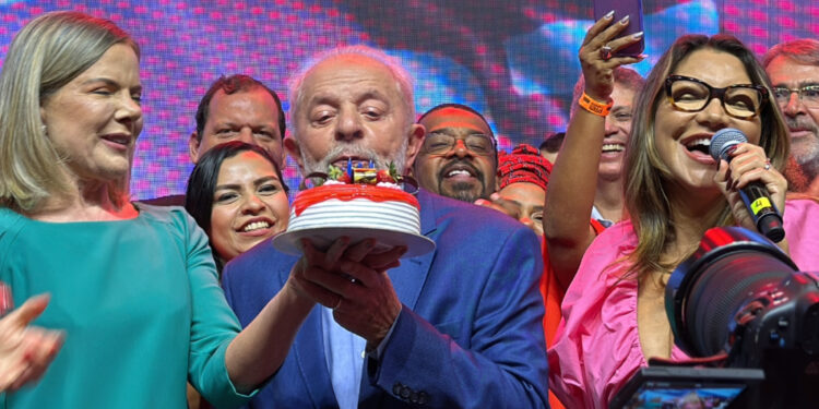 Lula apaga as velas do bolo do PT enquanto Janja canta "parabéns".
