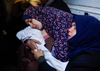 Rania Abu Anza, mãe dos gêmeos Wesam e Naeem Abu Anza, mortos  em Rafah, abraça os corpos dos filhos