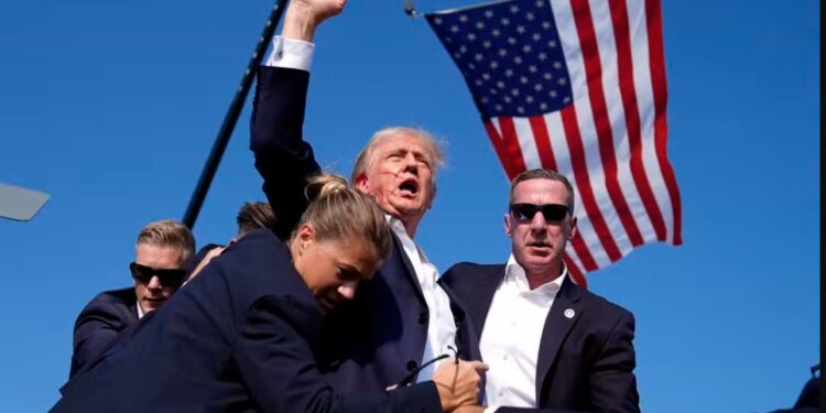 Donald Trump fazendo gesto de força e resistência após ataque