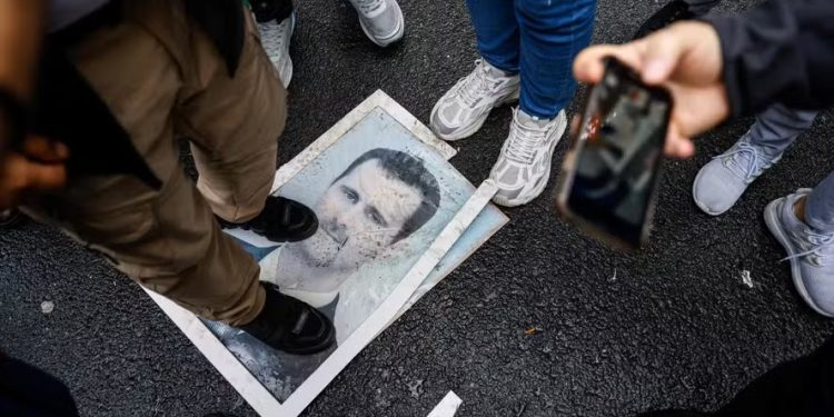 Manifestante pisa em fotografia de presidente Bashar al-Assad durante protesto do lado de fora de Consulado da Síria em Istambul