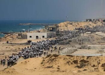 Palestinos carregam sacos de comida após ajuda humanitária chegar em Gaza