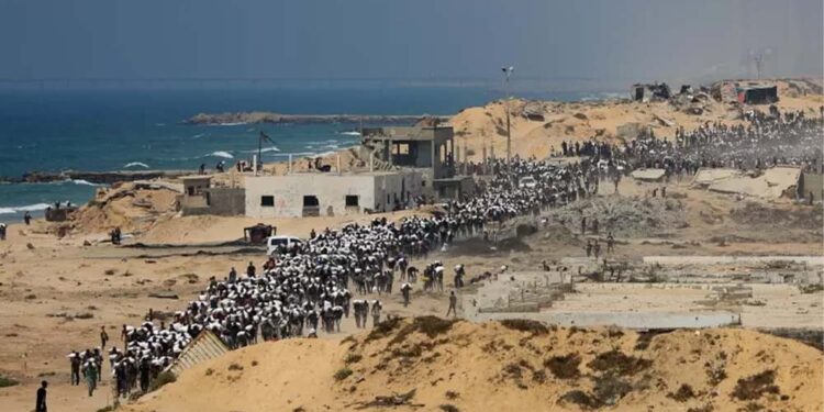 Palestinos carregam sacos de comida após ajuda humanitária chegar em Gaza