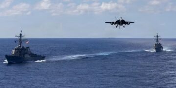 F-18 se aproxima do USS Gerald Ford com Mahan e Bainbridge ao fundo