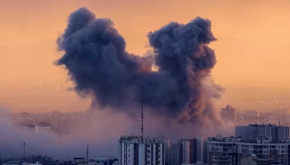 Uma coluna de fumaça se eleva após um ataque à capital iraniana