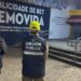 Dois agentes da Ordem Pública do Rio, com coletes azuis e bonés amarelos, observam área onde propaganda externa foi removida. Letreiro grande indica remoção de publicidade irregular em espaço público com piso de pedra portuguesa e escadaria ao fundo.
Agentes da Prefeitura do Rio de Janeiro removem anúncio de bet em espaço público