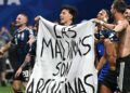 Jogadores argentinos com a faixa escrito 'As Malvinas são argentinas" no gramado