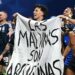 Jogadores argentinos com a faixa escrito 'As Malvinas são argentinas" no gramado